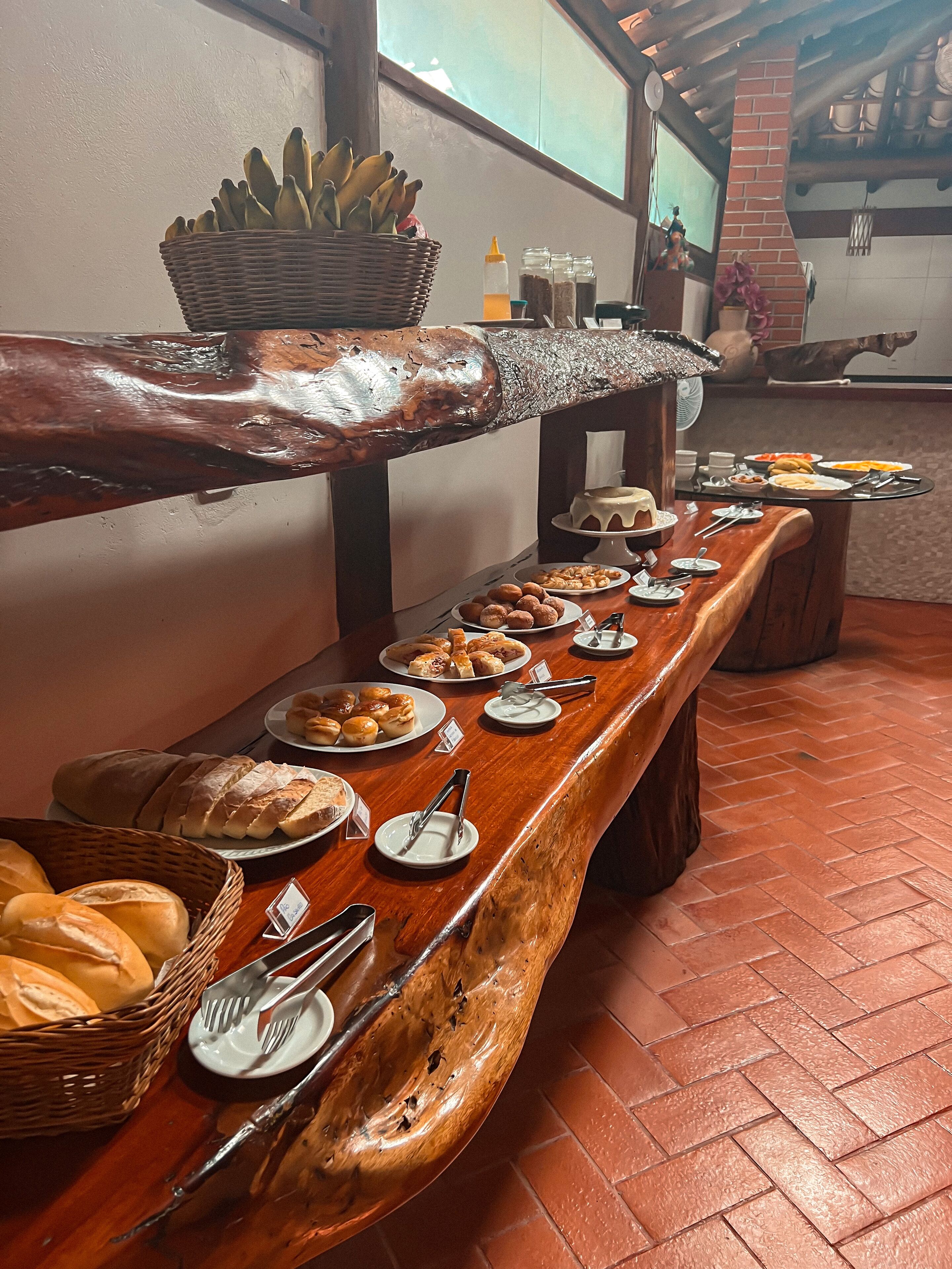 A buffet setup with various food items and utensils on a wooden table.