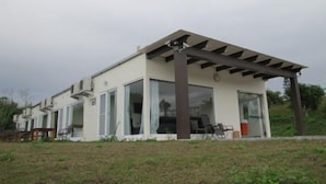 A modern two-story house with a flat roof, large glass windows, and a pergola structure. - Sunrise Villa (Beinan)
