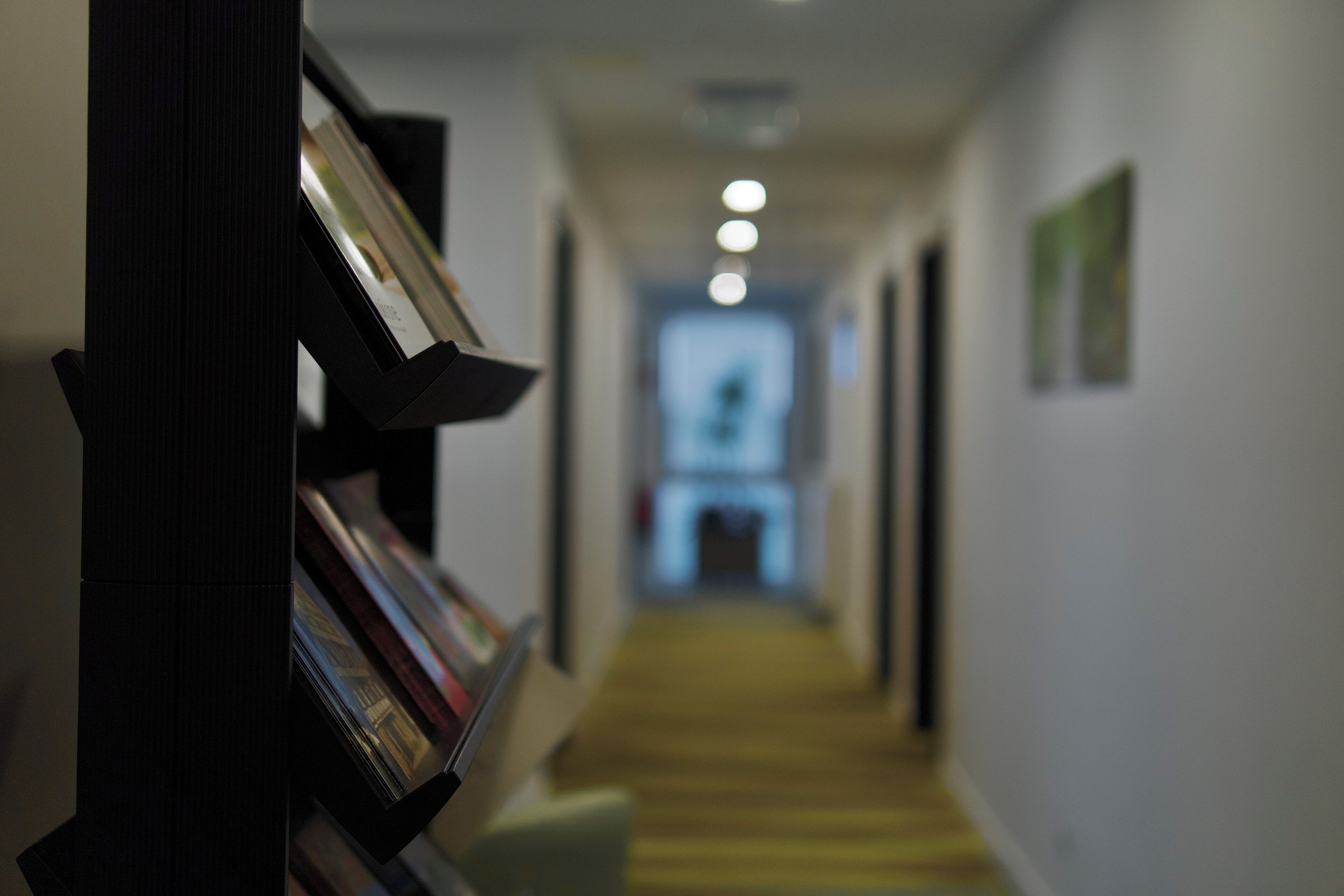 A hallway with a bookshelf and a staircase leading to a room.