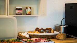 A kitchen counter with various food items, including bread, eggs, and a cutting board. -  B&B Outlet Hotel – Metzingen – Bad Urach - Free Parking (Dettingen an der Erms)