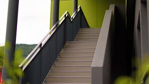 A staircase leading up to a building with a green wall and metal railings. -  B&B Outlet Hotel – Metzingen – Bad Urach - Free Parking (Dettingen an der Erms)