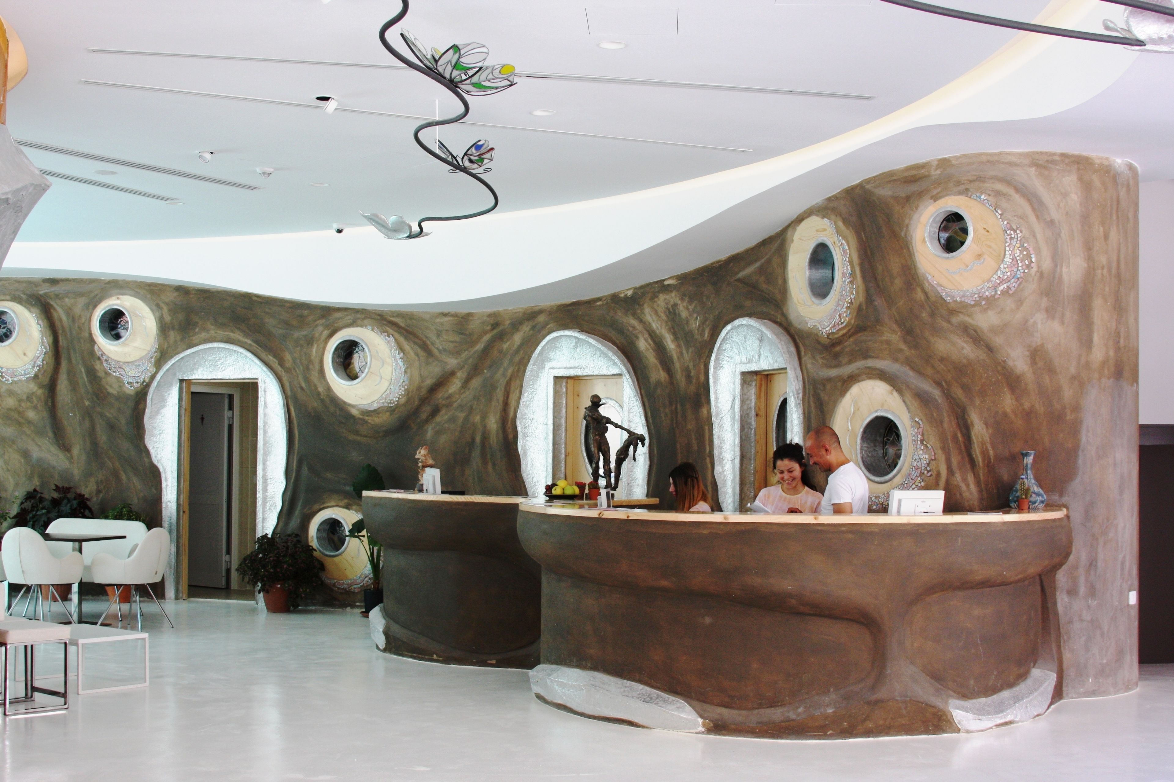 A reception area with a unique rock-like design, multiple archways, and a central counter.