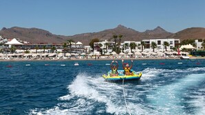 A water jet ski ride with a beach and mountains in the background. - Armonia Holiday Village & Spa (Bodrum)