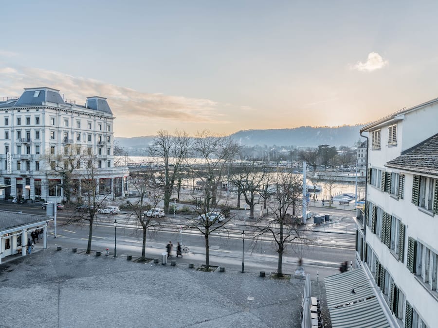 Une vue d’une ville avec ses bâtiments, une rue et un paysage enneigé.