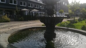 A fountain in a courtyard with a building in the background. - Wittgensteiner Landhaus - Adult Only (Winterberg)