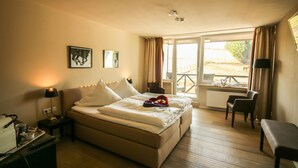 A hotel room with a bed, a desk with a lamp, a chair, and a view of the outdoors. - Wittgensteiner Landhaus - Adult Only (Winterberg)