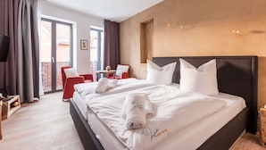 A hotel room with a large bed, a TV, a balcony with a red chair, and a small table. - Ringelnatz Inselhotel Malchow (Malchow)