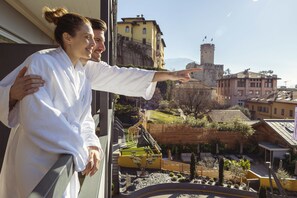A view from a window overlooking a courtyard with a castle, a yellow building, and a tower. - Hi Hotel - Wellness & Spa Adults Only (Trento)