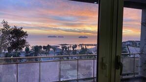 A balcony with a view of the sea and ships, palm trees, and a tiled floor. - La Casa sul Mare (Civitavecchia)