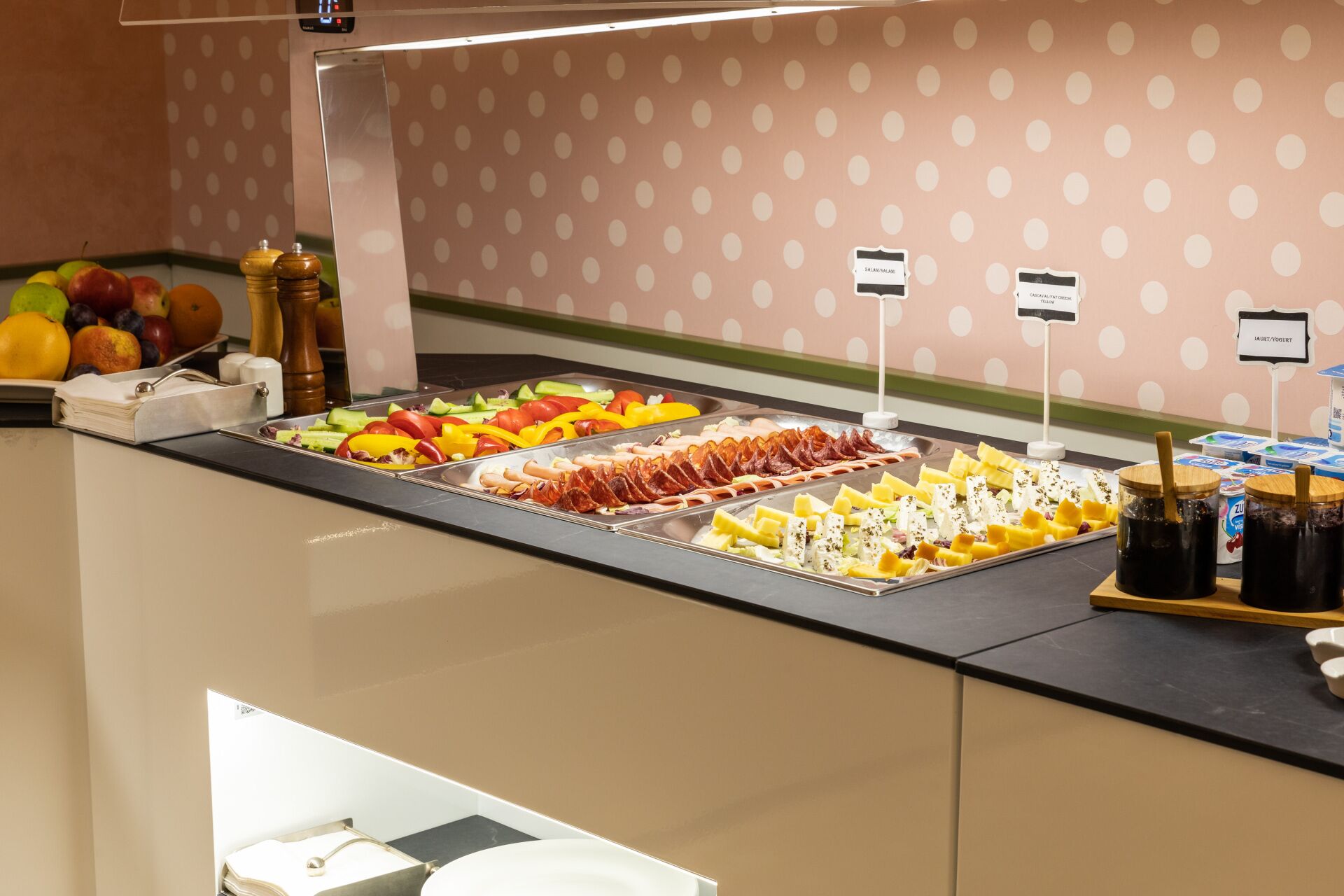 A buffet with various food items including fruits, vegetables, meats, and dairy products.