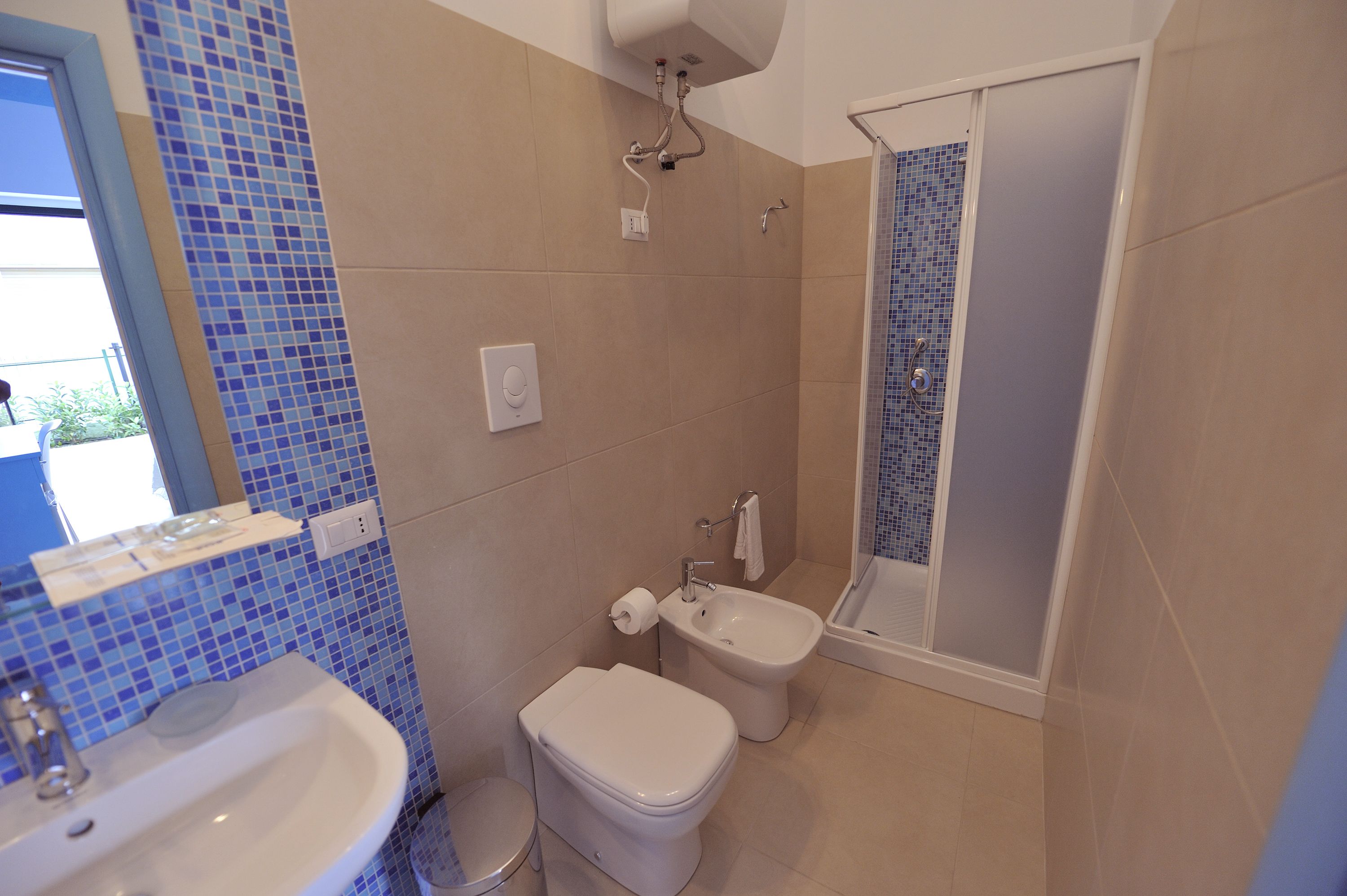 Une salle de bain équipée d’un lavabo, de toilettes, d’un bidet et d’une douche.