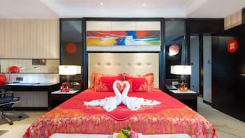 Habitación de hotel con una cama grande, un escritorio y una silla. Hay un cuadro en la pared y un letrero rojo en la puerta.