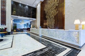 A hotel lobby with a reception desk, seating area, and decorative wall panels. - Dading Century Plaza Hotel (Chengdu)
