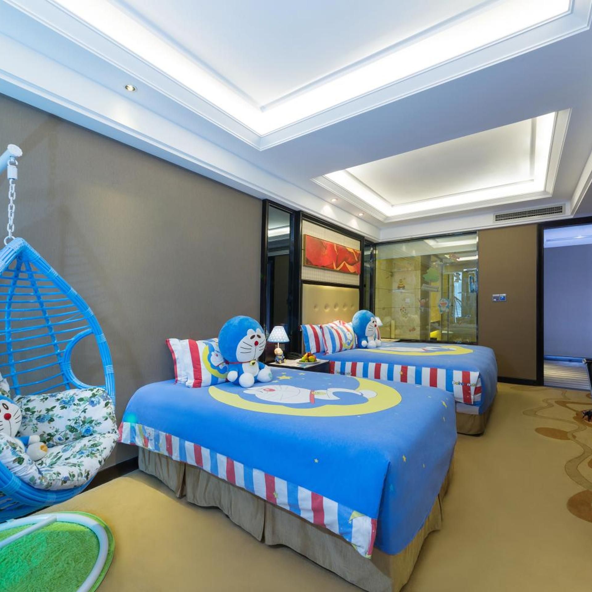 Habitación de hotel con dos camas, un sillón colgante y un ventanal grande.