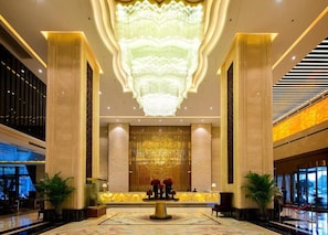 A lobby with a large chandelier, marble columns, and a reception desk. - Dading Century Plaza Hotel (Chengdu)