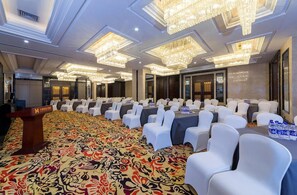 A conference room with rows of white chairs, a podium, and a patterned carpet. - Dading Century Plaza Hotel (Chengdu)