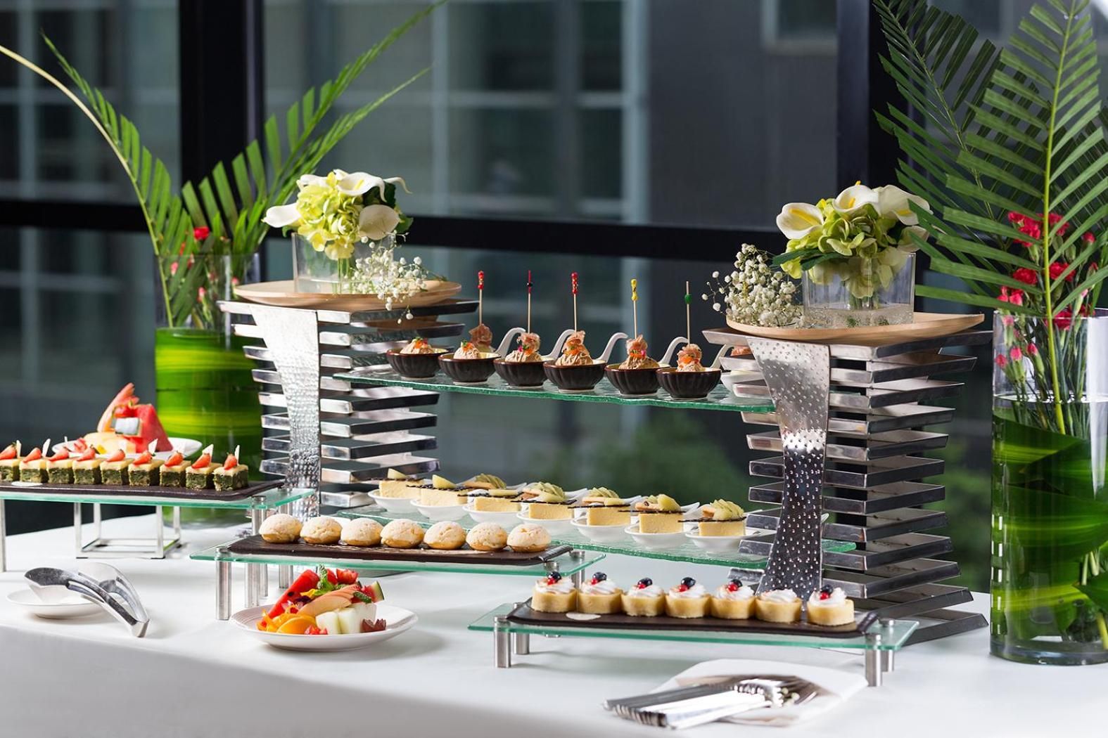 A buffet setup with various food items and decorative elements.