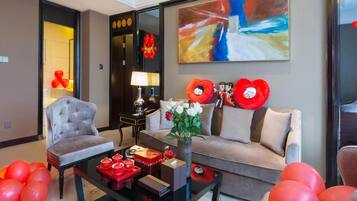 A modern living room with a sofa, armchairs, a coffee table, and a painting on the wall.