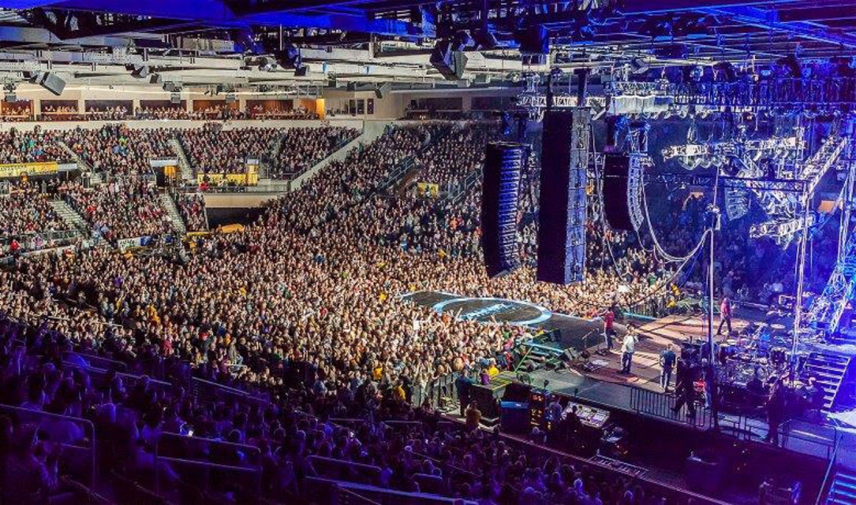 A large indoor venue with multiple levels of seating, a stage, and a complex lighting system.