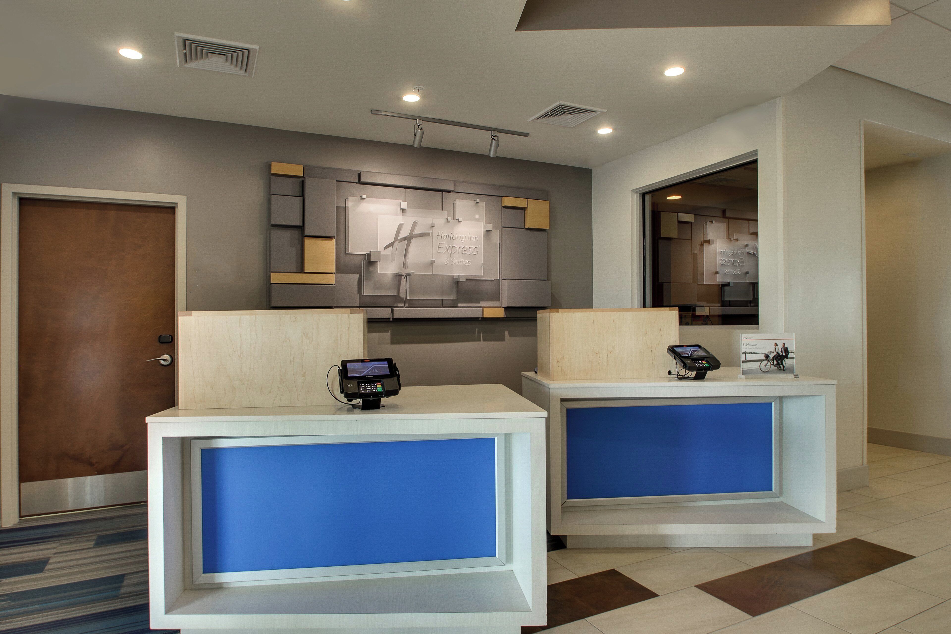 A reception area with two reception desks, a wall-mounted sign, and a door.