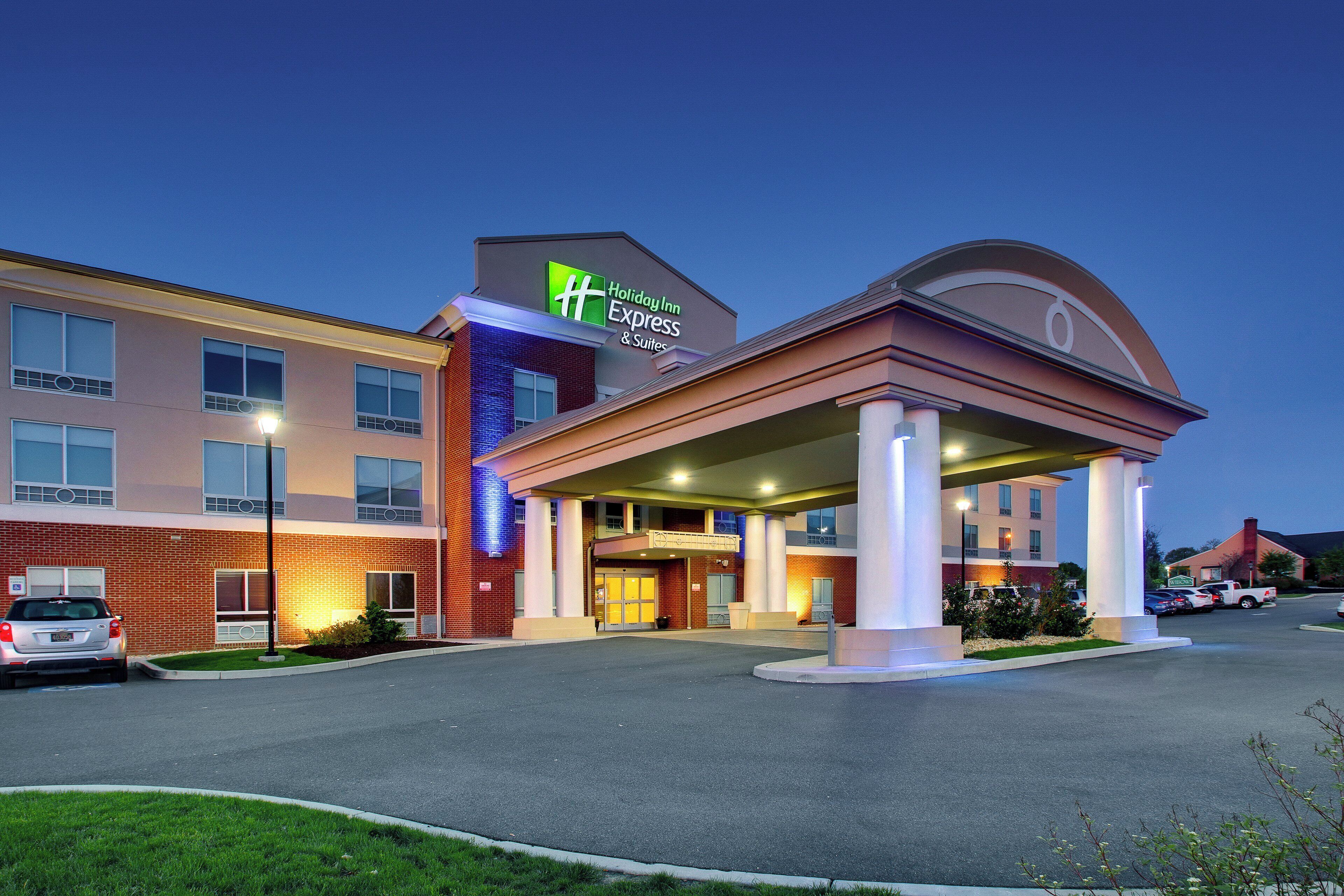 Un hotel Holiday Inn Express & Suites con fachada de ladrillo, entrada cubierta y estacionamiento.