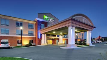 Un hotel Holiday Inn Express & Suites con fachada de ladrillo, entrada cubierta y estacionamiento.