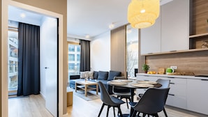 Een moderne woonruimte met een eethoek, keuken en zithoek.