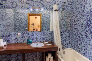 A bathroom with a wooden vanity, a sink, and a bathtub. - Happy Porto Hostel & Apartments (Porto)