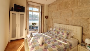 Quarto com cama, guarda-roupa, televisão e vista para o exterior.