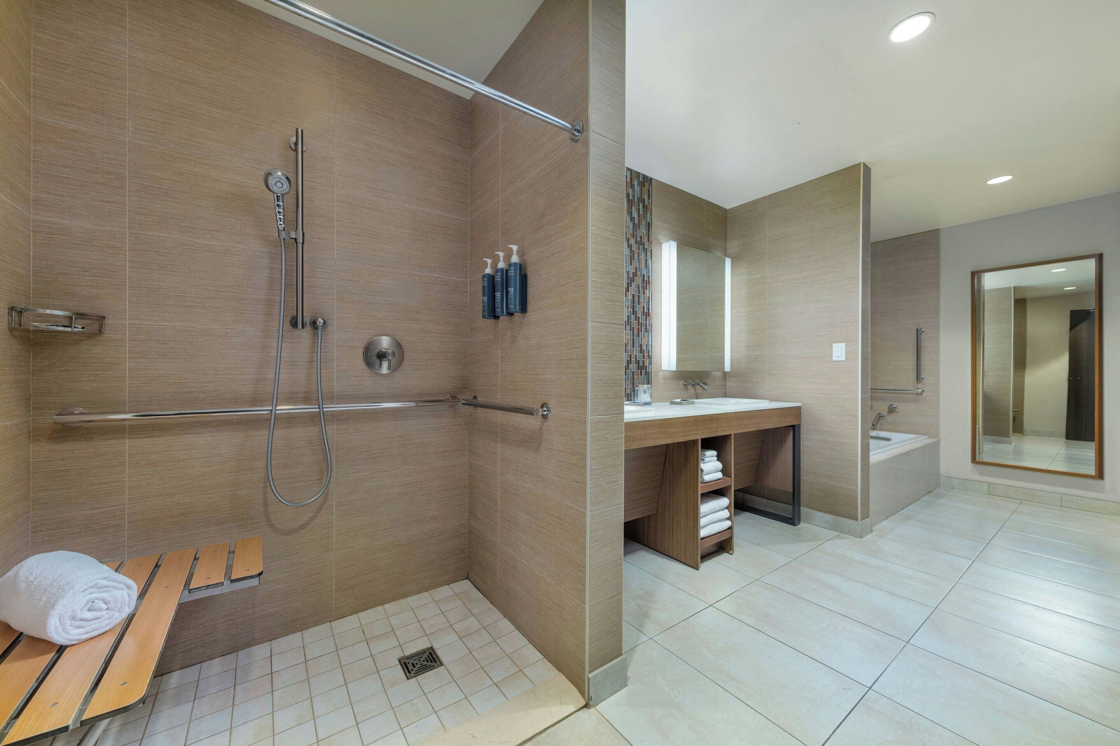 A modern bathroom with a shower, toilet, and sink.