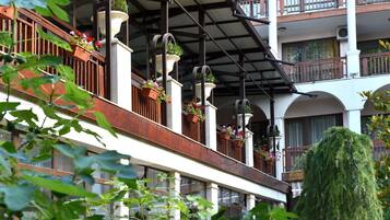A multi-story building with balconies, wooden railings, and hanging flower planters.