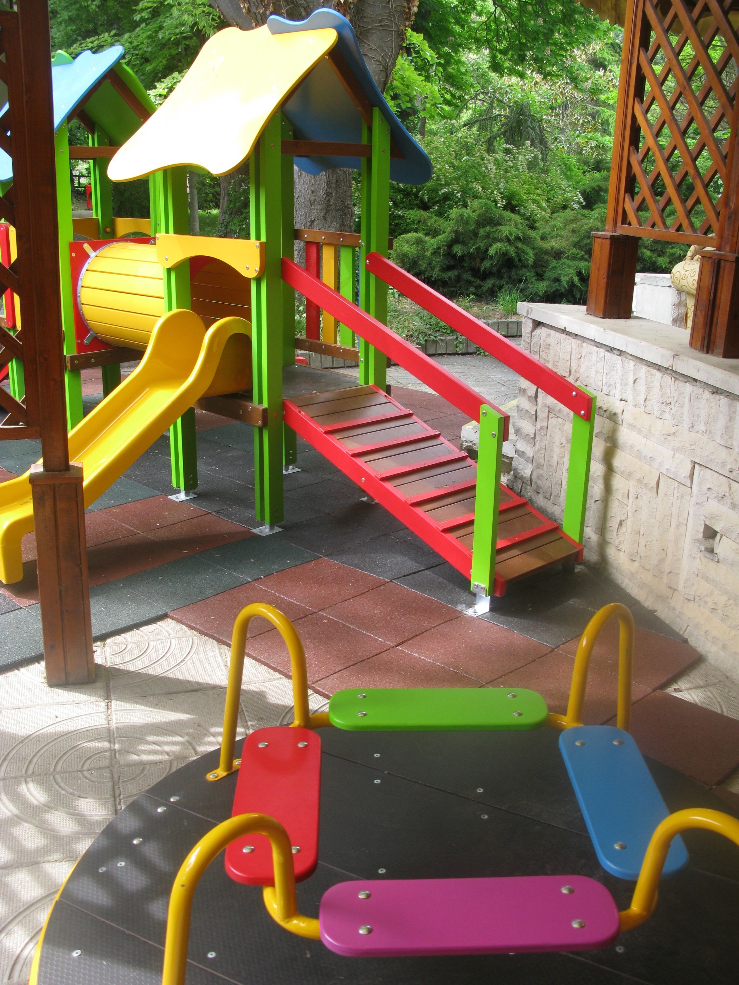 Un parque infantil con tobogán, escaleras de acceso y equipamiento de gimnasia.