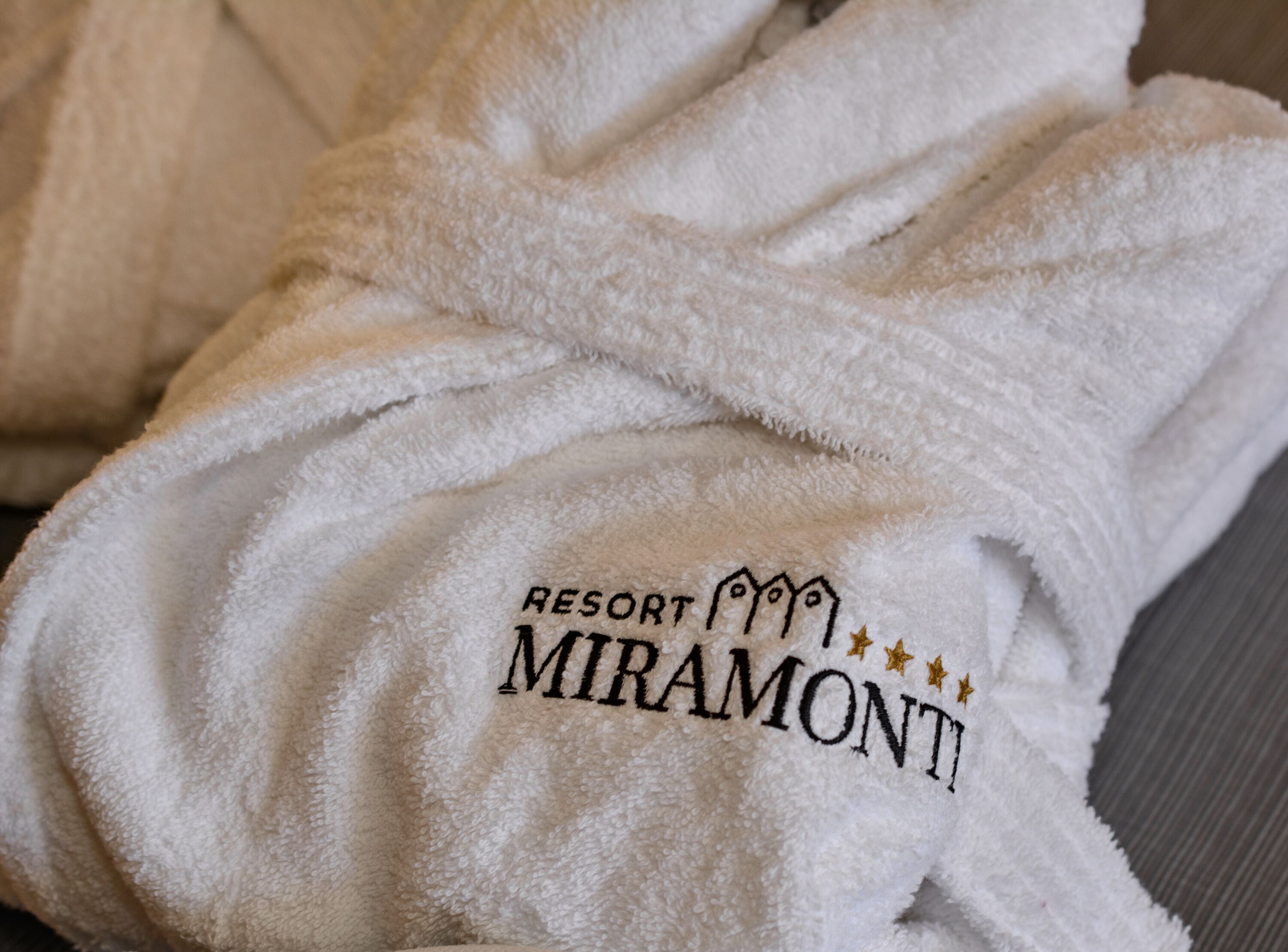 Ein weißes Handtuch mit eingesticktem Schriftzug "RESORT MIRAMONTI".