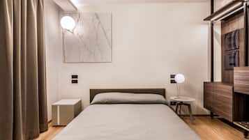Quarto moderno com cama, mesas de cabeceira, luminária na parede e cômoda de madeira.