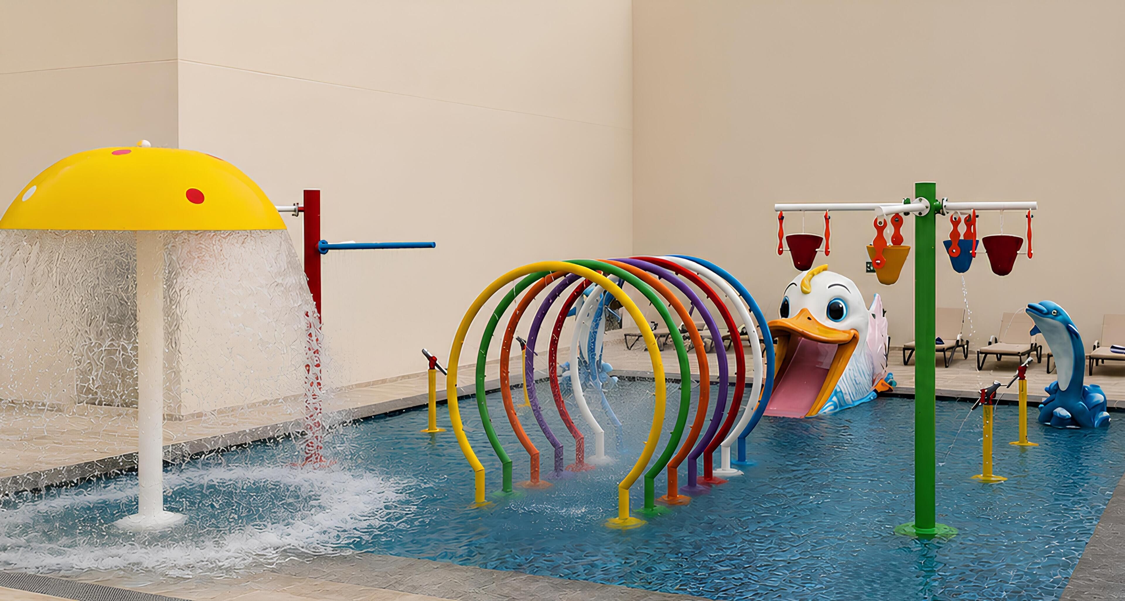 A swimming pool with a water feature, colorful slides, and a dolphin-shaped play structure.