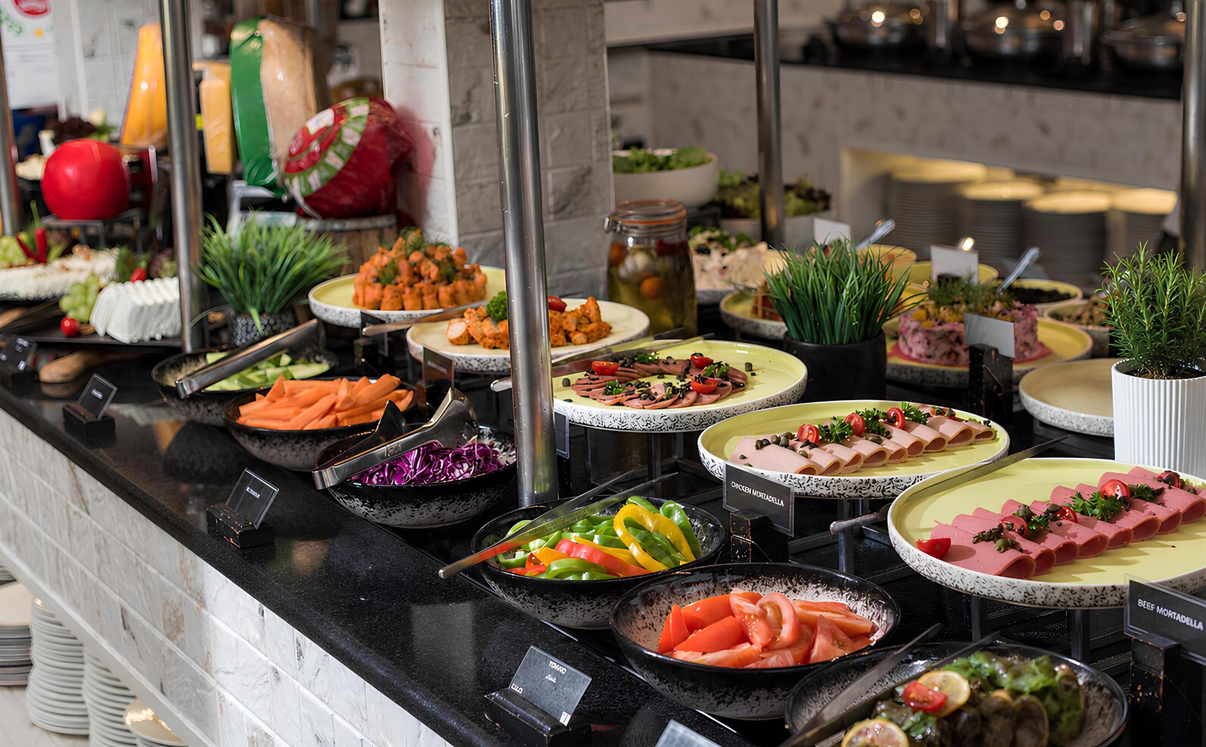 Un buffet proposant une variété de plats, notamment des salades, de la viande et des légumes.