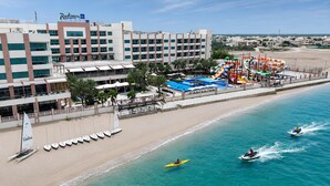 Un hotel con piscina, playa y actividades acuáticas.