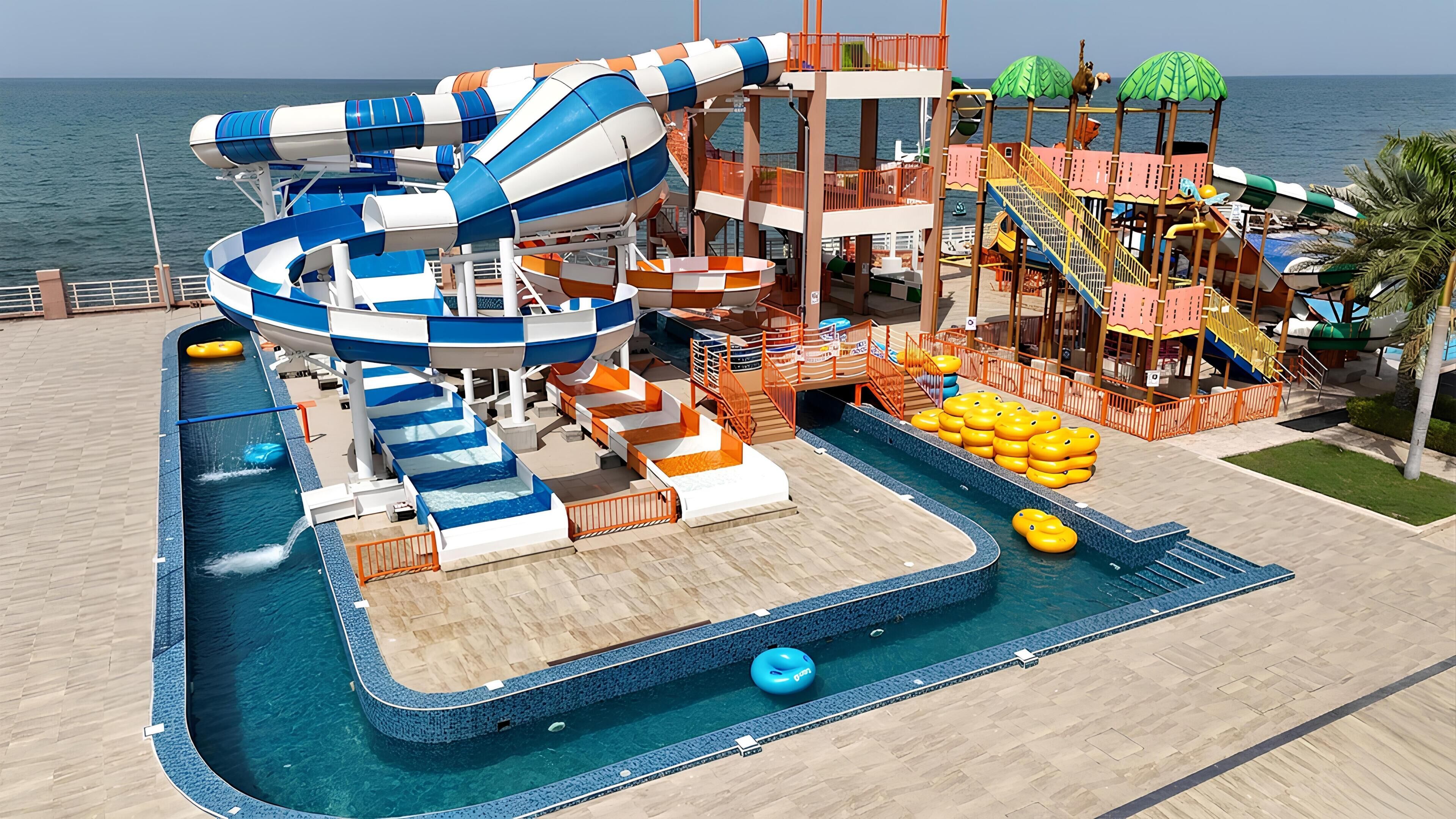 Un parque acuático con toboganes, piscina y zona de juegos.