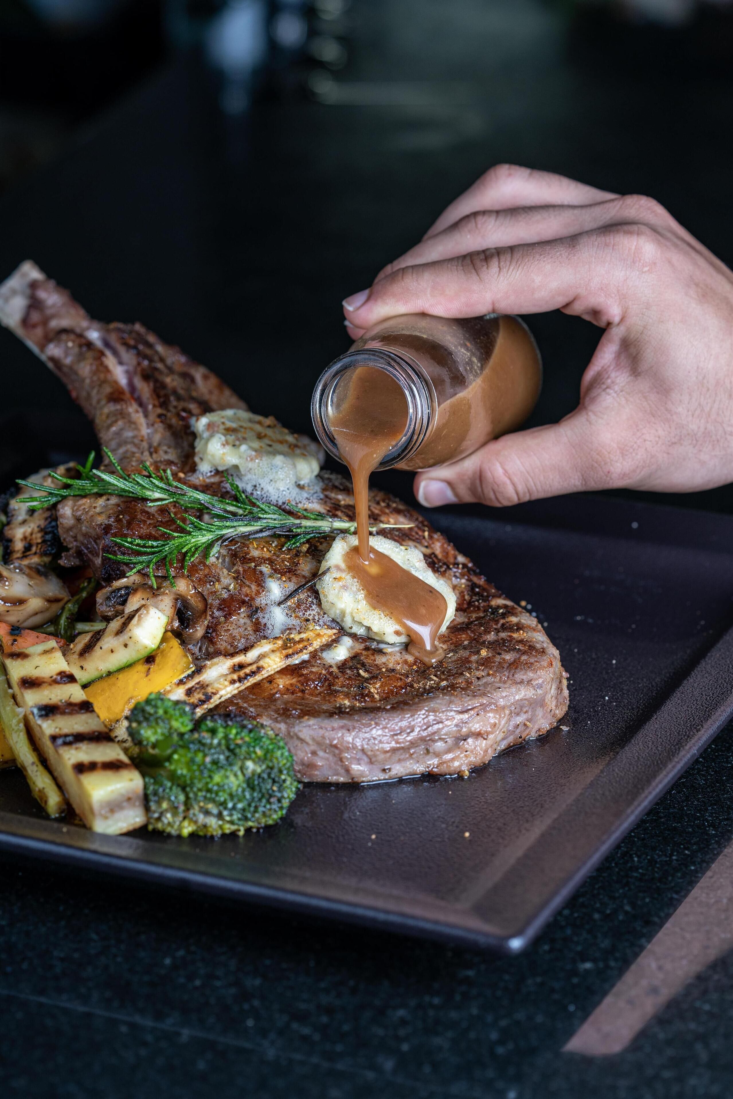 Ein Steak mit Gemüse und Soße auf einem Teller.