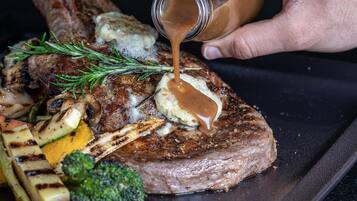 Ein Steak mit Gemüse und Soße auf einem Teller.