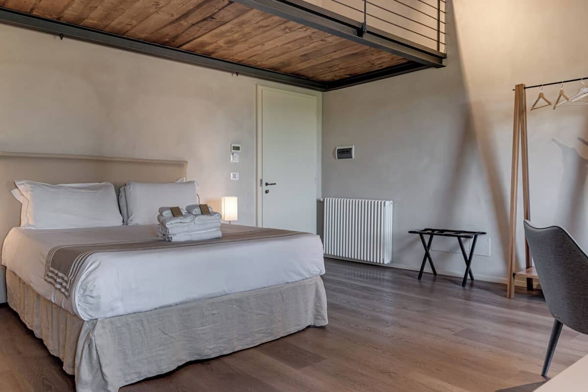 Een slaapkamer met een bed, nachtkastjes, een radiator en een kapstok.
