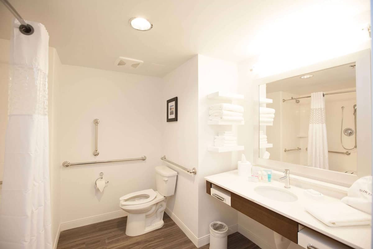 A modern bathroom with a toilet, sink, and shower.