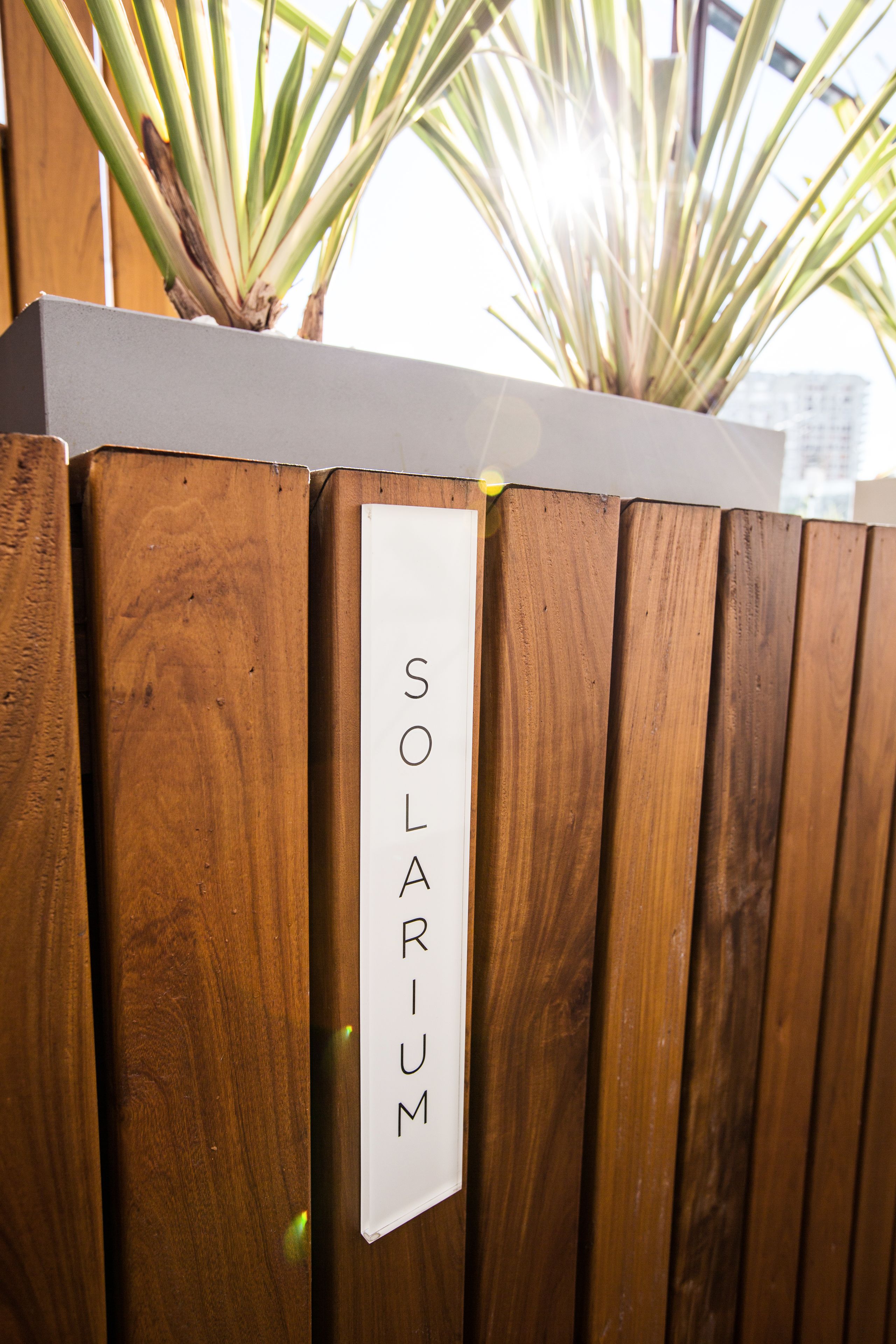 A wooden fence with a sign that reads "SOLARIUM".