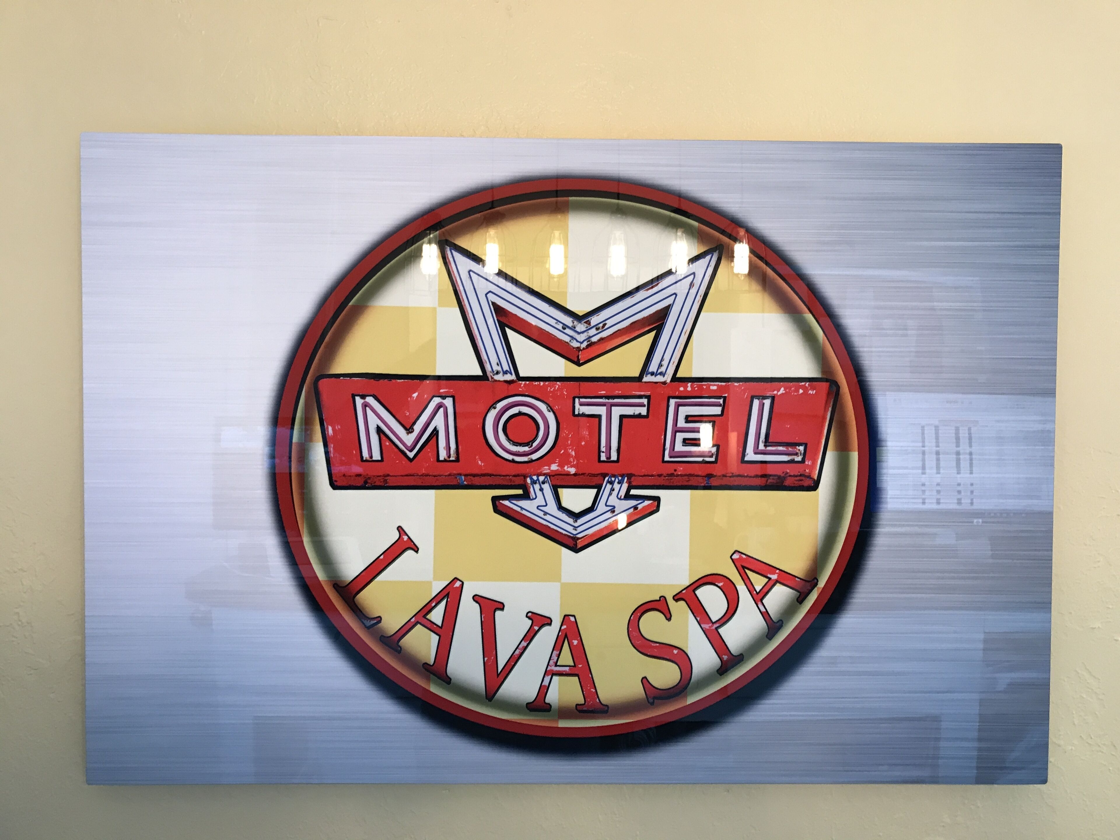 Un letrero circular con las palabras "Motel Lava Spa" en letras rojas y negritas sobre un fondo amarillo y blanco.