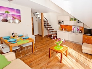 Um apartamento moderno com sala de jantar, cozinha e área de estar.