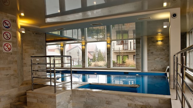 Ein Innenpool mit Steinwänden und Blick auf benachbarte Gebäude.