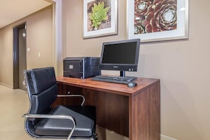 A hotel office with a desk, computer, and chair. - Suburban Studios Midland I-20 (Midland)