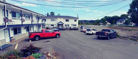 A motel with a parking lot, a red pickup truck, and a white van.