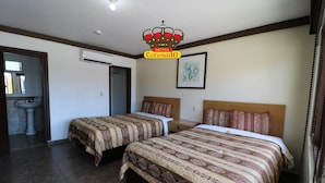 A hotel room with two beds, a bathroom, and a framed artwork on the wall. - Hotel Coronado (Ensenada)