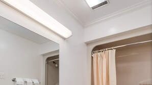 Un baño moderno con lavamanos doble, inodoro y ducha con cortina color beige.